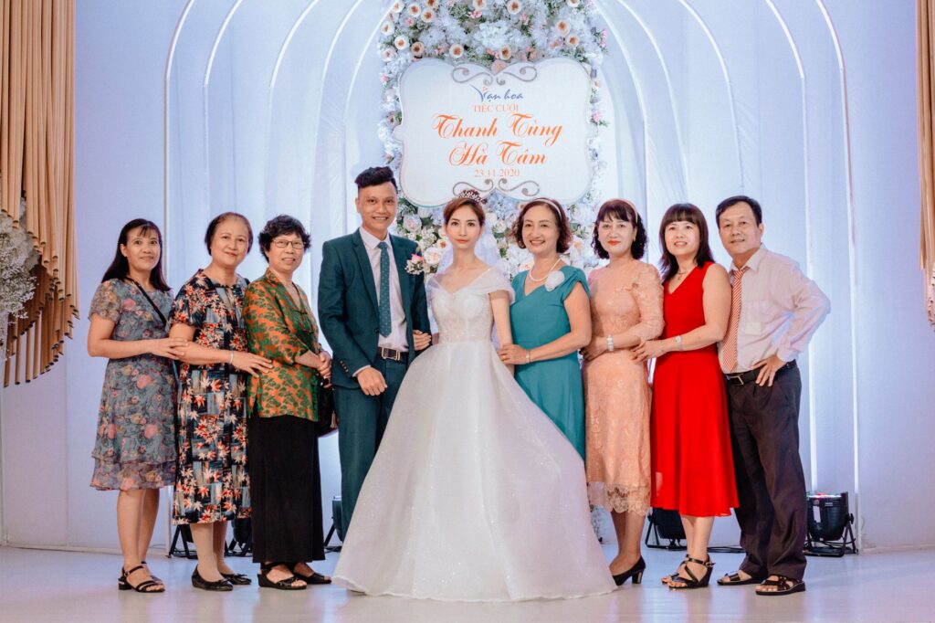 A happy family poses with the bride and groom at a vibrant wedding celebration.