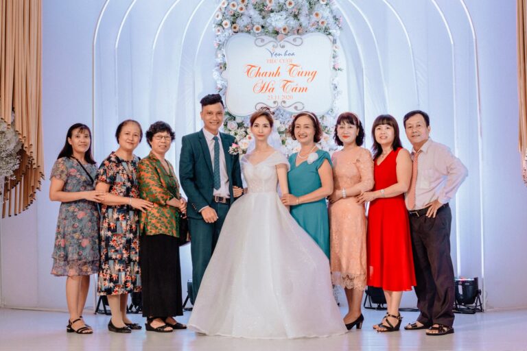A happy family poses with the bride and groom at a vibrant wedding celebration.